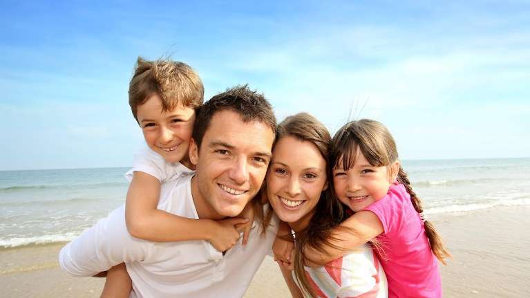 family smiling on the beach