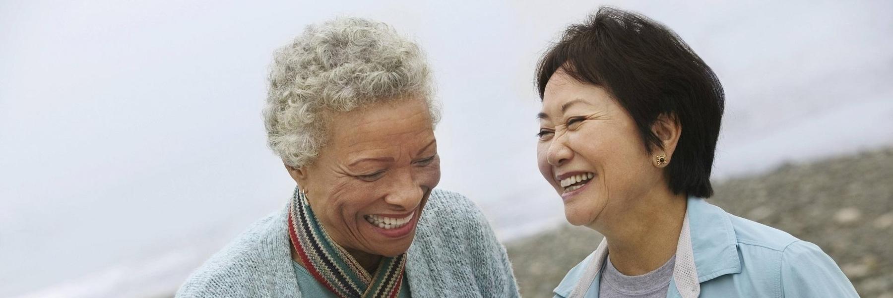 women laughing on beach with dental bridges in Mount Waverley