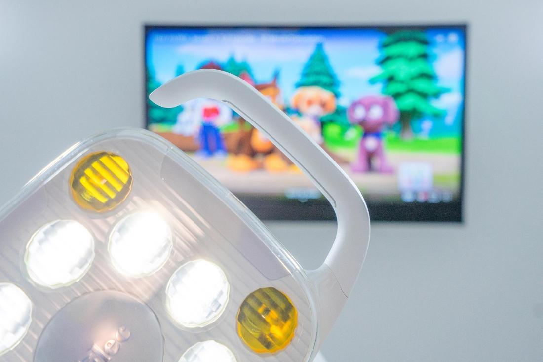 Light above dental chair with Tv in room